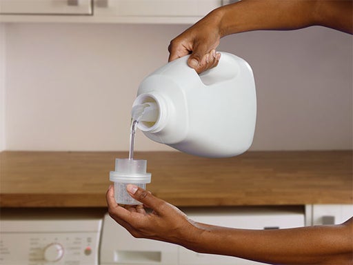 pouring detergent into measuring cup